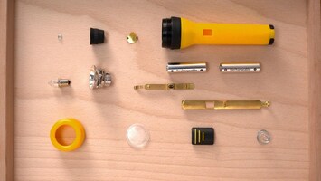 Die Einzelteile einer Taschenlampe liegen geordnet nebeneinander. Das Gehï¿½use der Taschenlampe ist gelb.