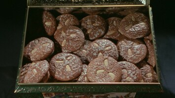 Runde Schokoladenplï¿½tzchen mit Mandeln dekoriert in einer Metalldose