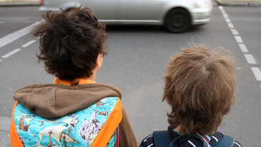 Zwei Kinder überqueren die Straße