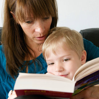 Mutter liest mit ihrem Sohn ein Buch.