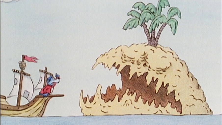 Käpt’n Blaubär segelt auf einem Holzschiff und vor ihm erscheint eine Insel mit einer Palme, die aussieht wie ein Hai mit offenem Mund