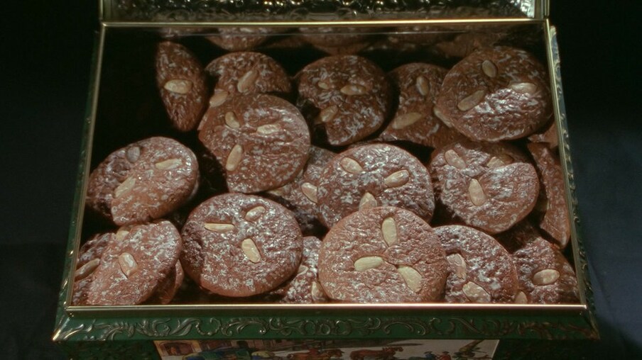 Runde Schokoladenplätzchen mit Mandeln dekoriert in einer Metalldose