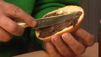 Christoph beschmiert ein Brot mit Nussnougatcreme