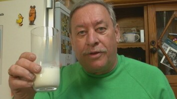 Christoph hï¿½lt ein Milchglas in der Hand