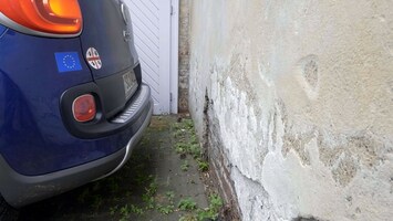Ein Rï¿½cklicht eines dunkelblauen Autos vor einer Wand