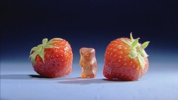 Gummibärchen zwischen zwei Erdbeeren