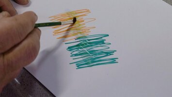Ein grï¿½ner Filzstift malt auf einem weiï¿½en Blatt Papier.