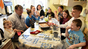 Eine Familie sitzt gemeinsam am Tisch