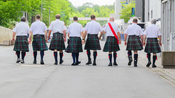 Eine Gruppe von Männern trägt karierte Schottenröcke