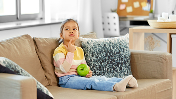 Mädchen nachdenklich auf einem Sofa