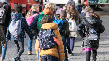 Schulkinder auf dem Weg zur Schule mit ihren Rucksäcken