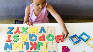 Mädchen spielt mit Buchstaben