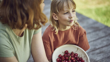 Kinder mit Kirschen in einer Schüssel