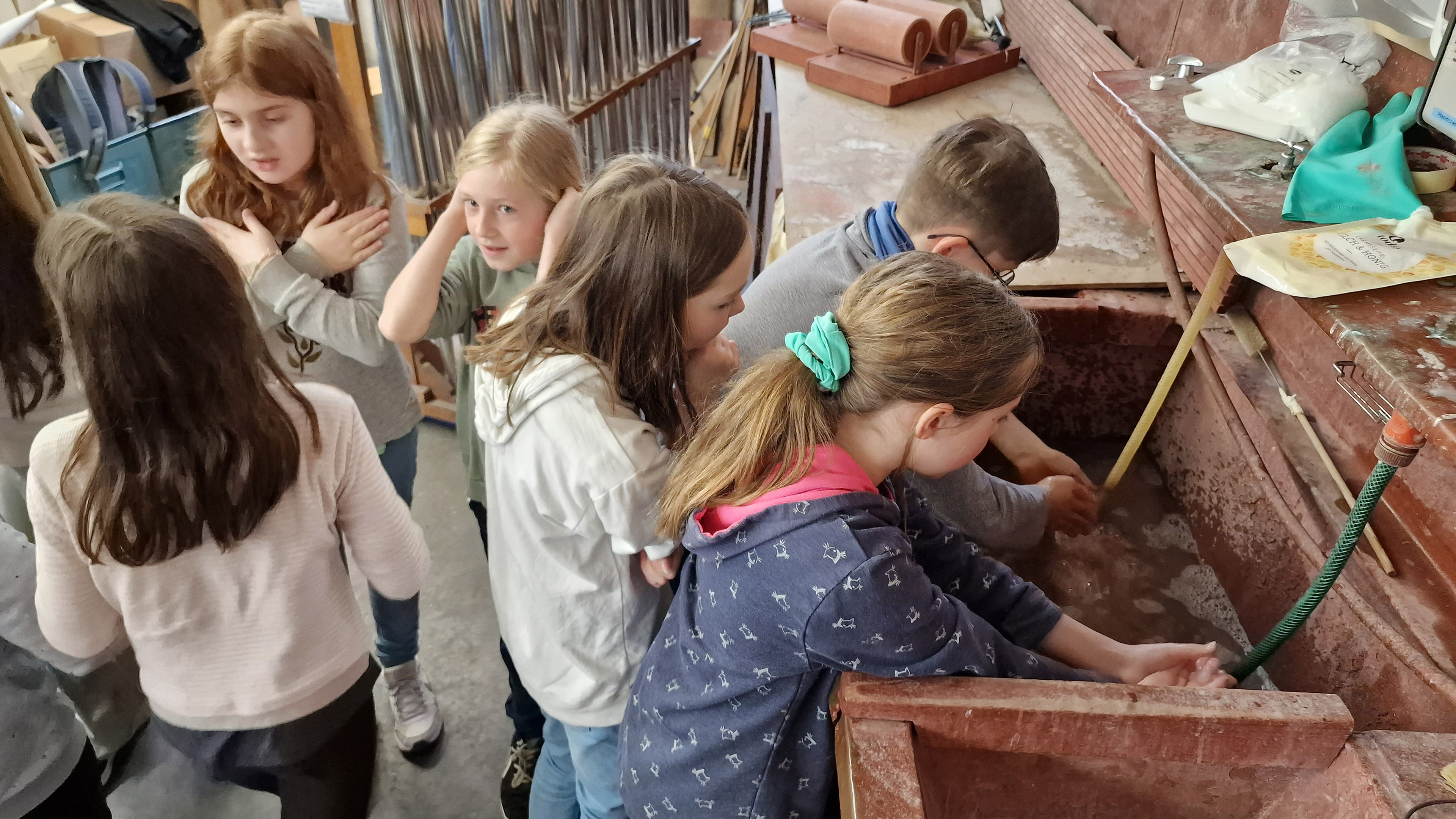 Kinder waschen sich in einem großen Werkstatt-Becken die Hände