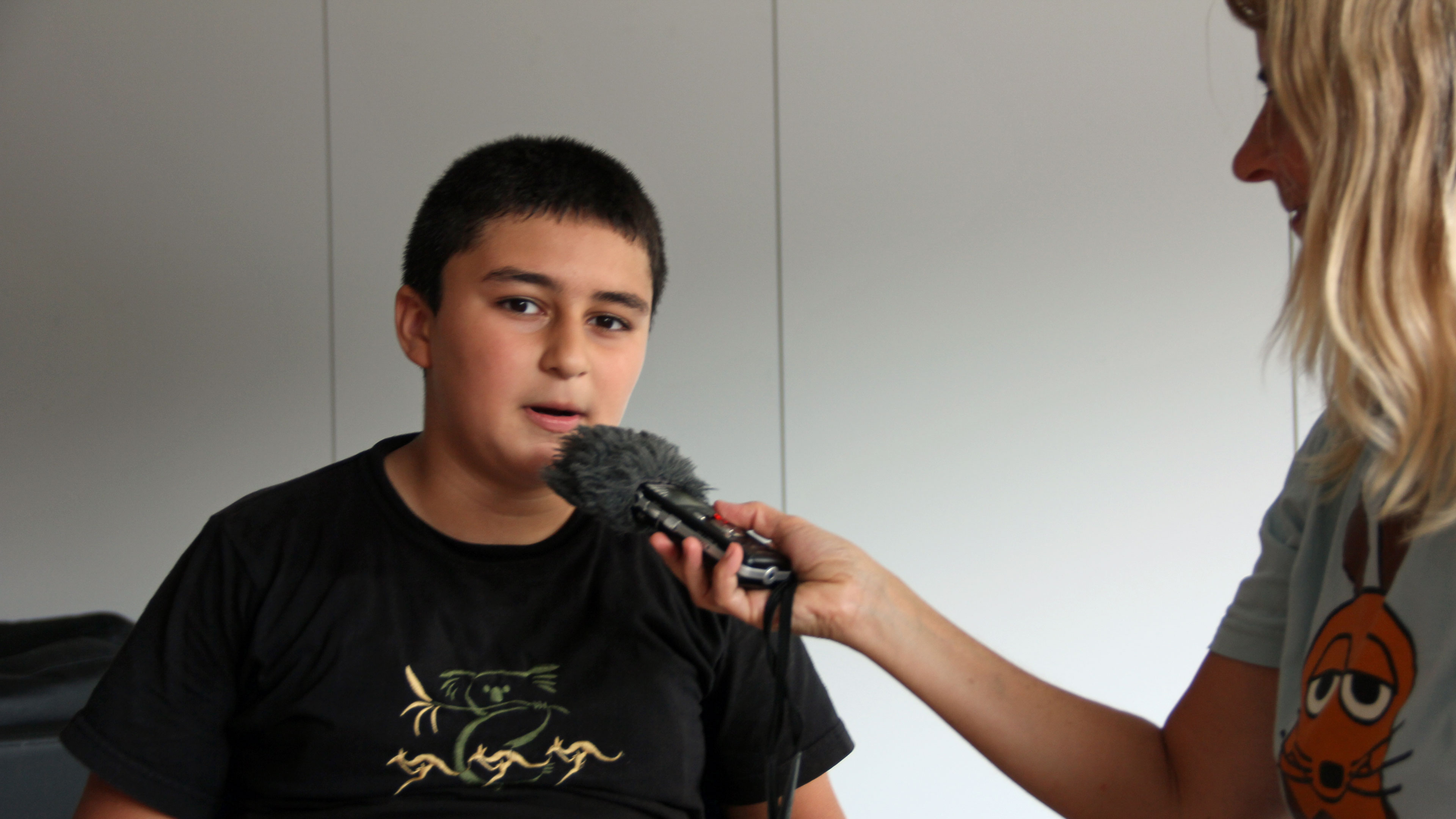 Ein Kind spricht in ein Aufnahmegerät
