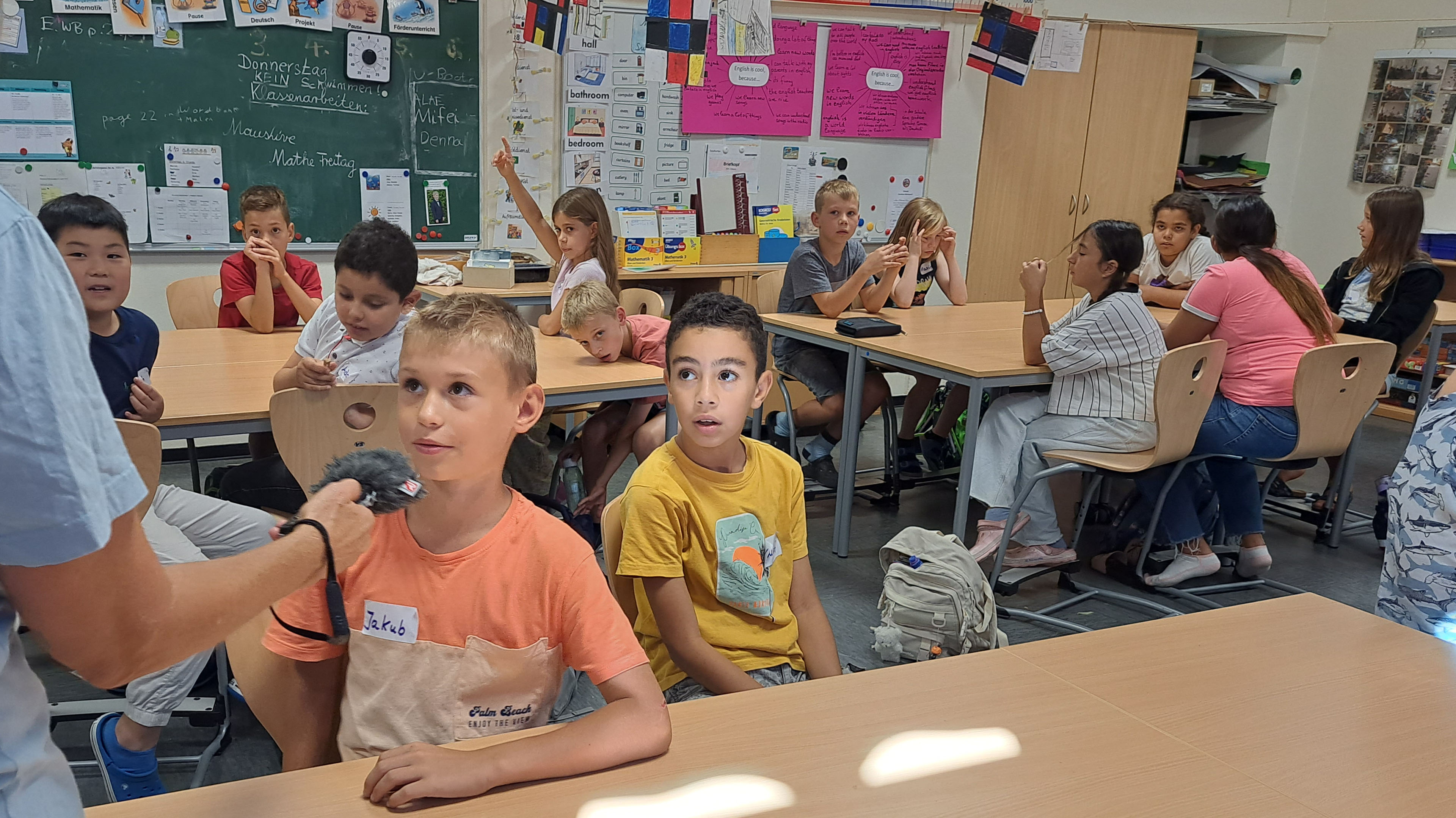 Ein Junge wird in seiner Schulklasse von MausReporterin Christina interviewt