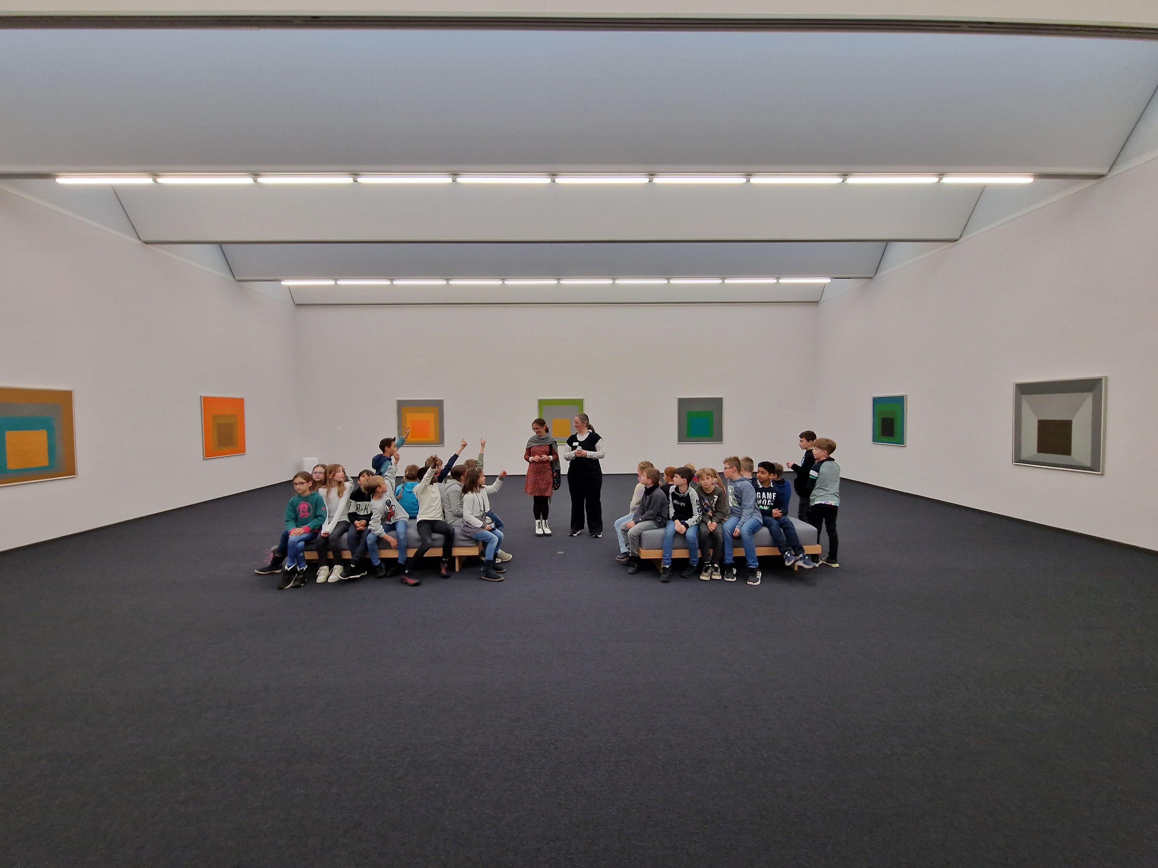 Eine Schülergruppe sitzt in einem Museum