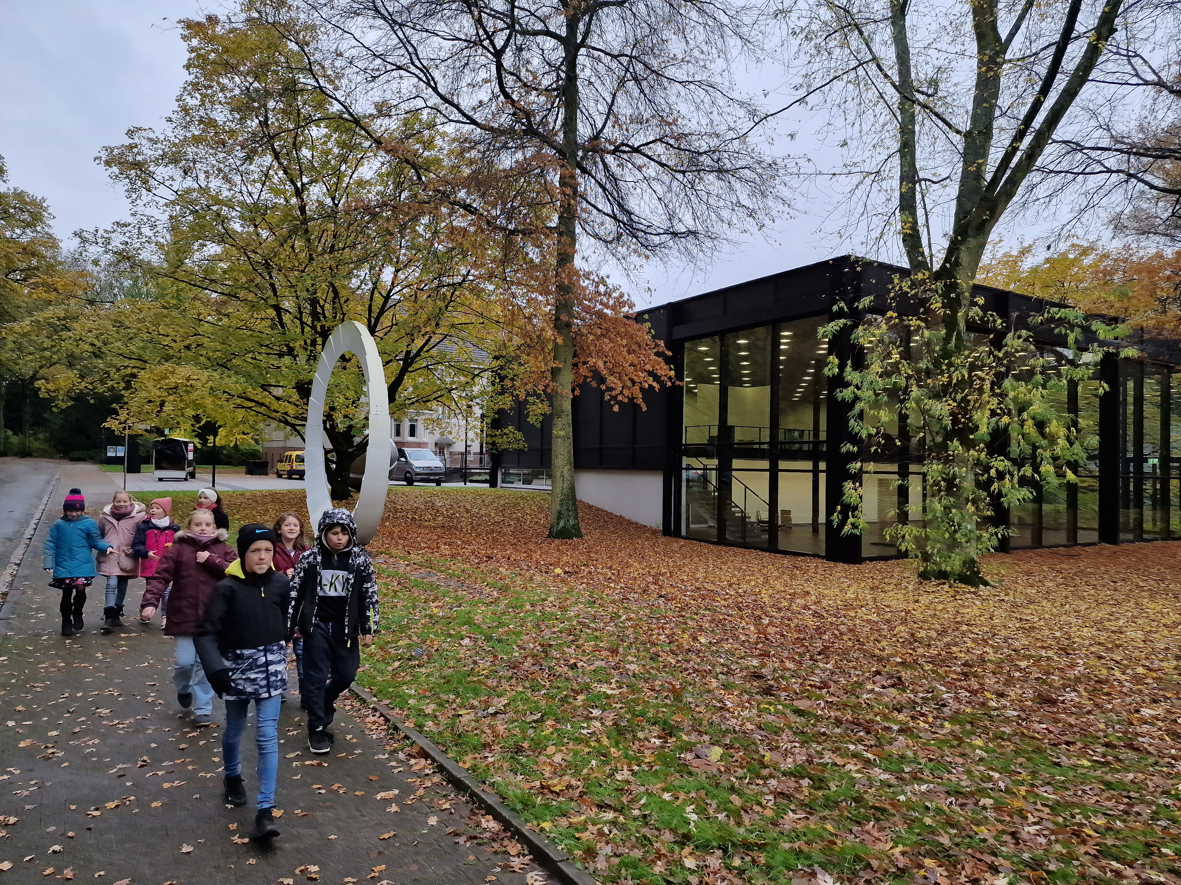 Eine Schulklasse geht an einem schwarzen Gebäude vorbei