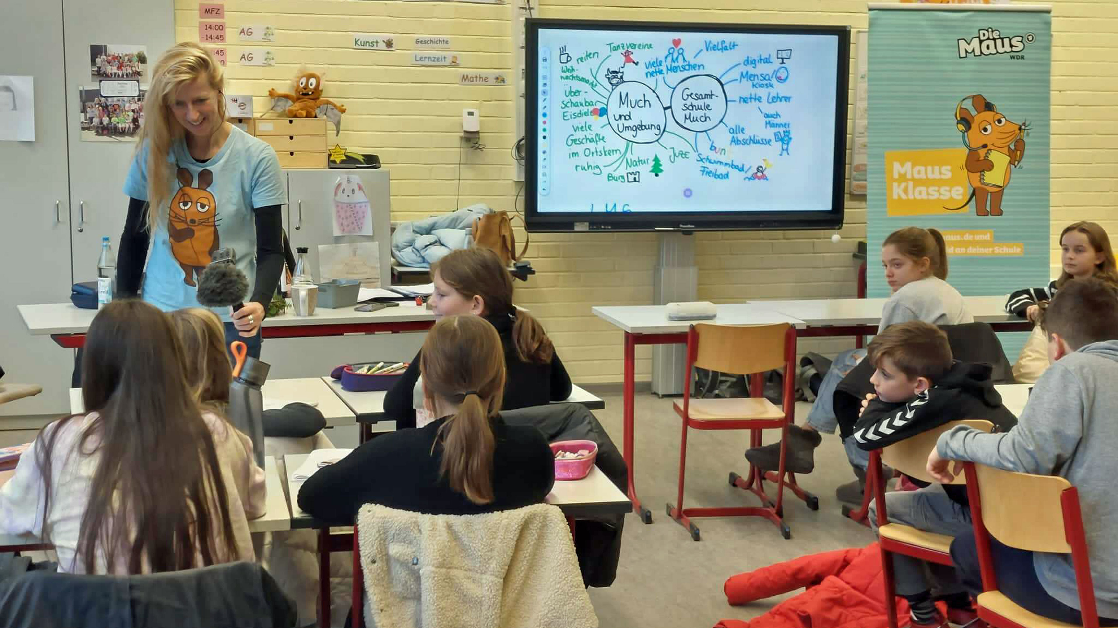 Eine Reporterin interviewt Kinder in einer Schulklasse