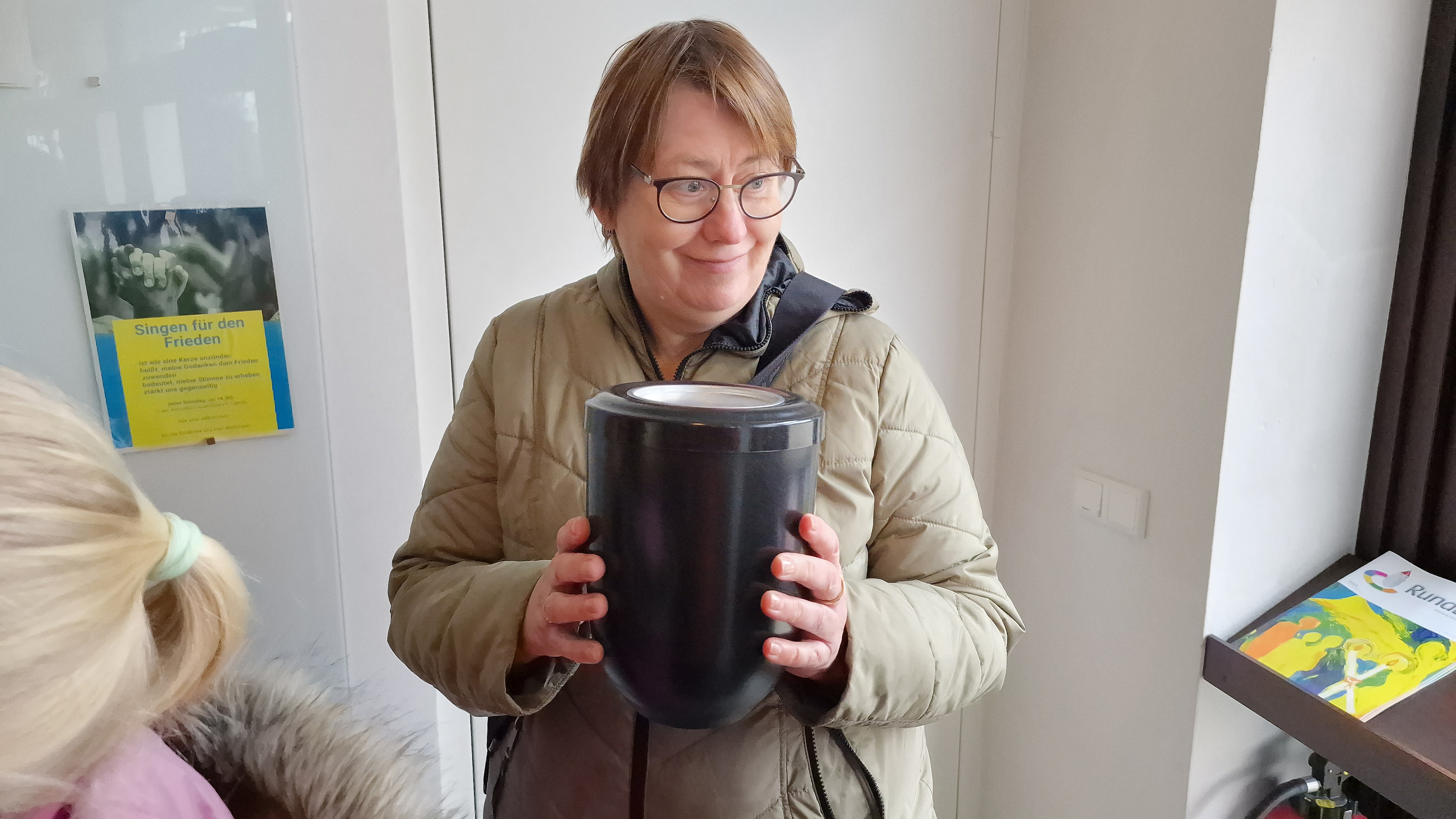 Die Gemeindereferentin Gisela Eiken-Fabian hält eine Urne in der Hand