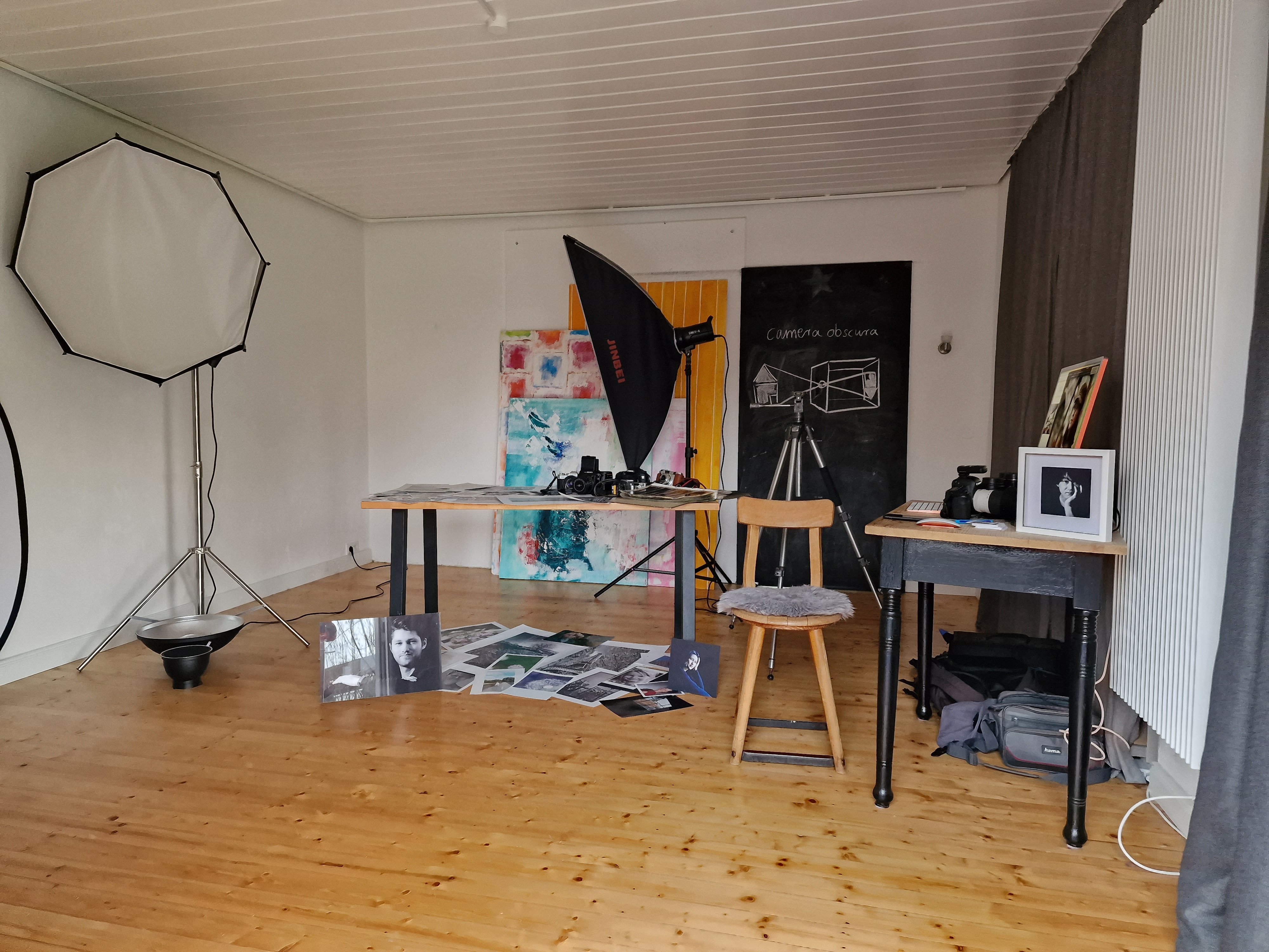 Ansicht eines Fotostudios mit Scheinwerfern und Schirmen.