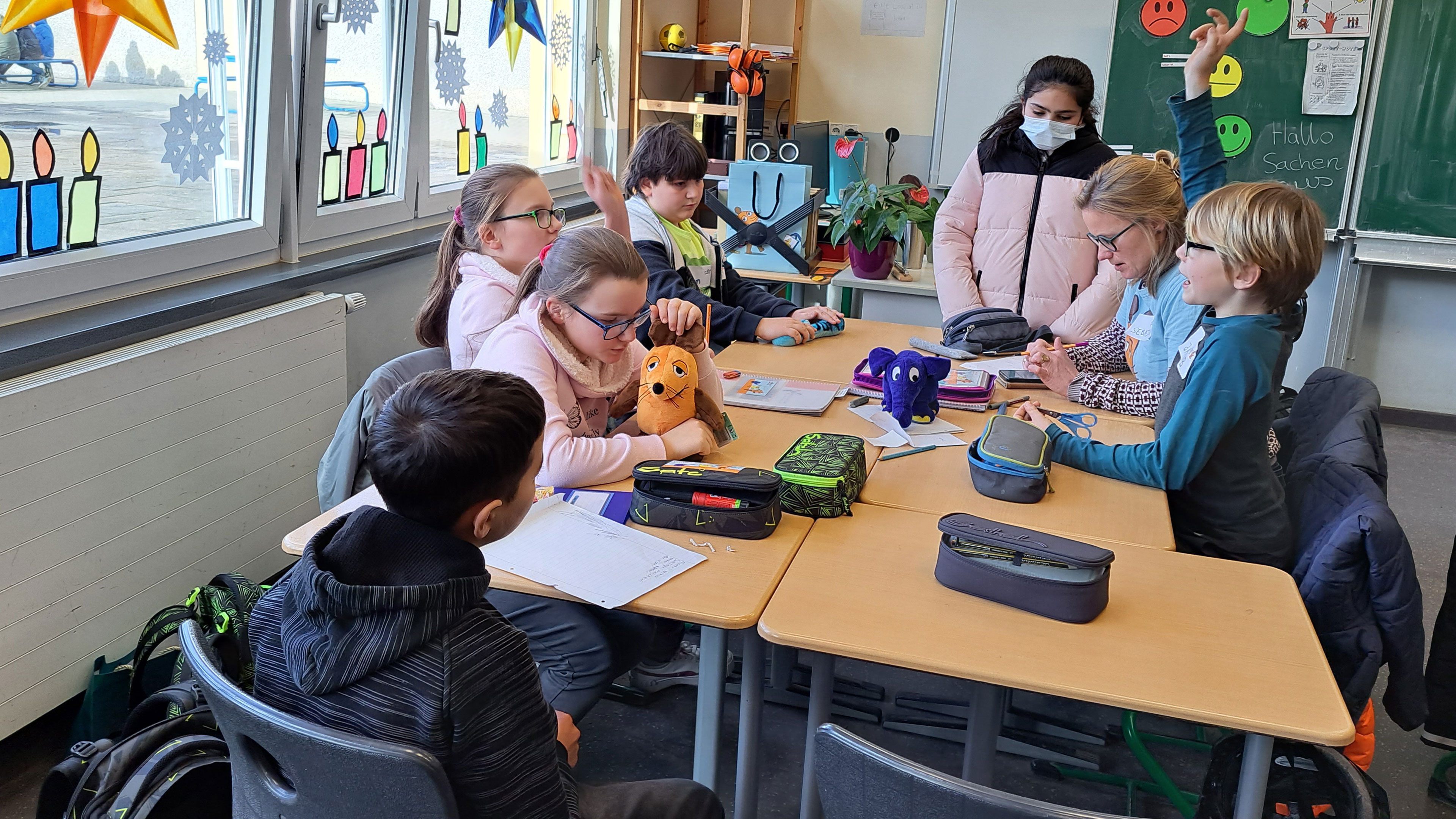 Eine Schülergruppe arbeitet in einem Klassenraum zusammen.