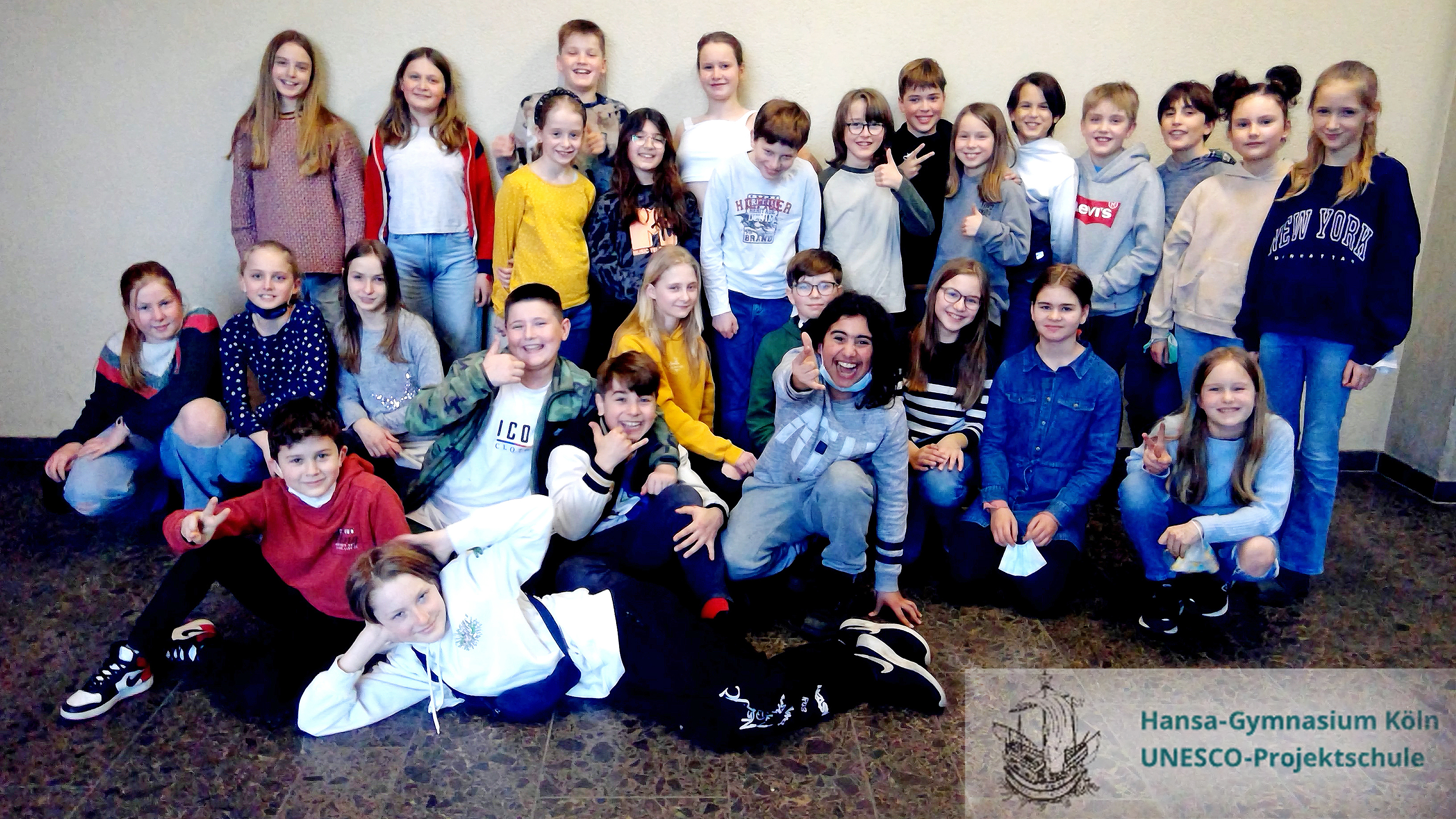 Gruppenfoto der Kinder mit Schullogo