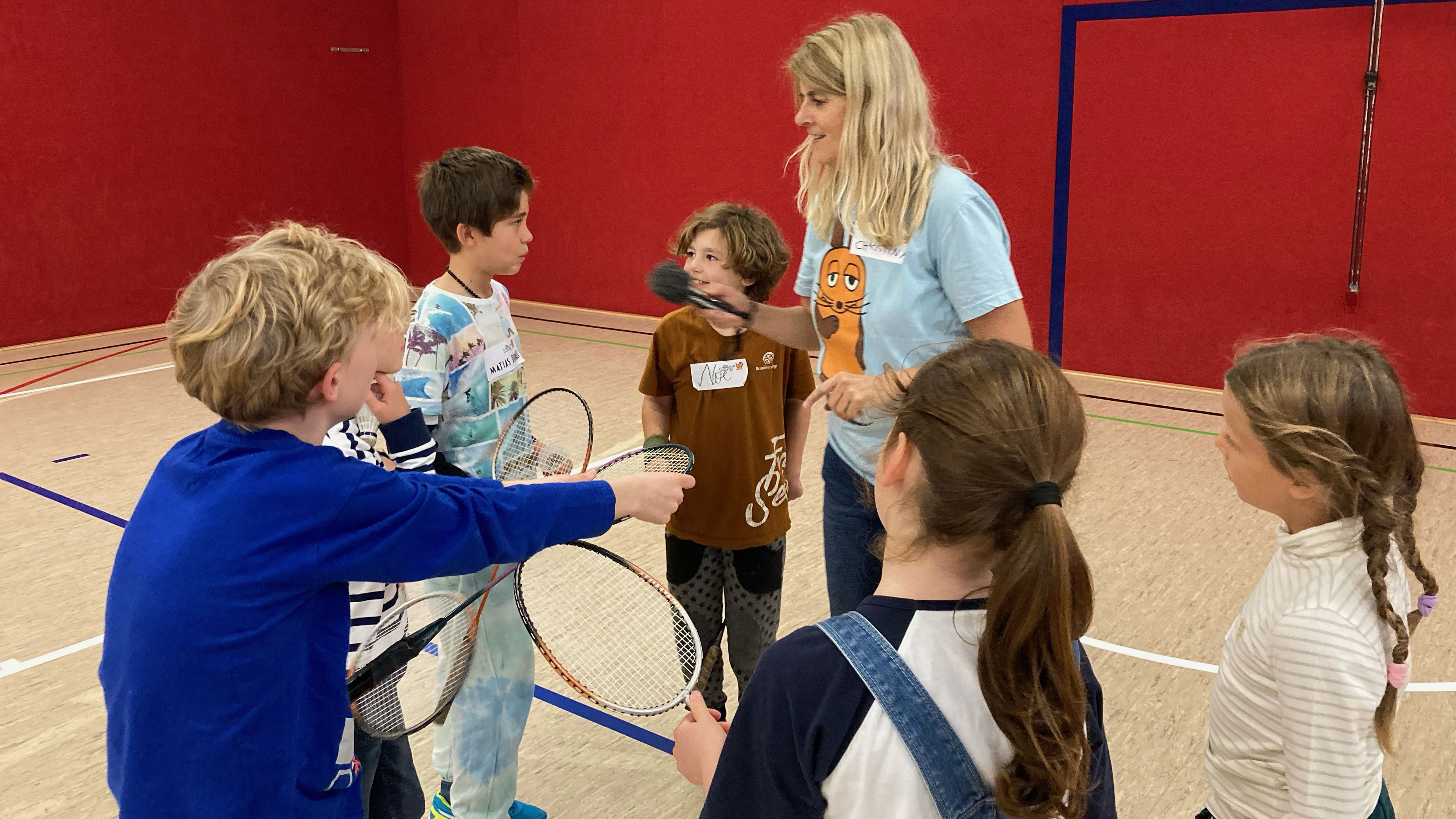 Kinder stehen in einer Turnhalle im Kreis.