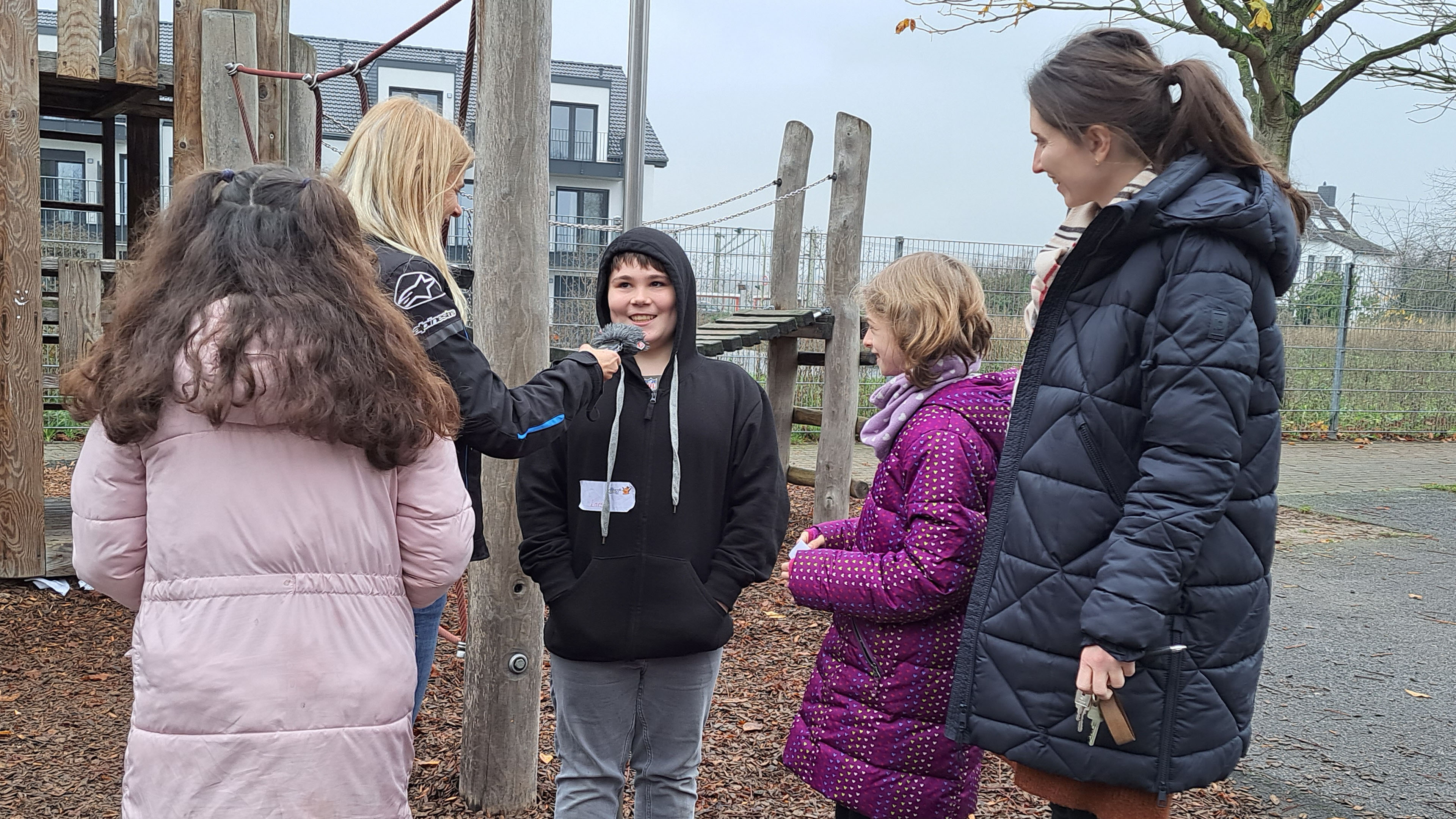 Ein Junge spricht auf dem Schulhof in ein Mikrofon