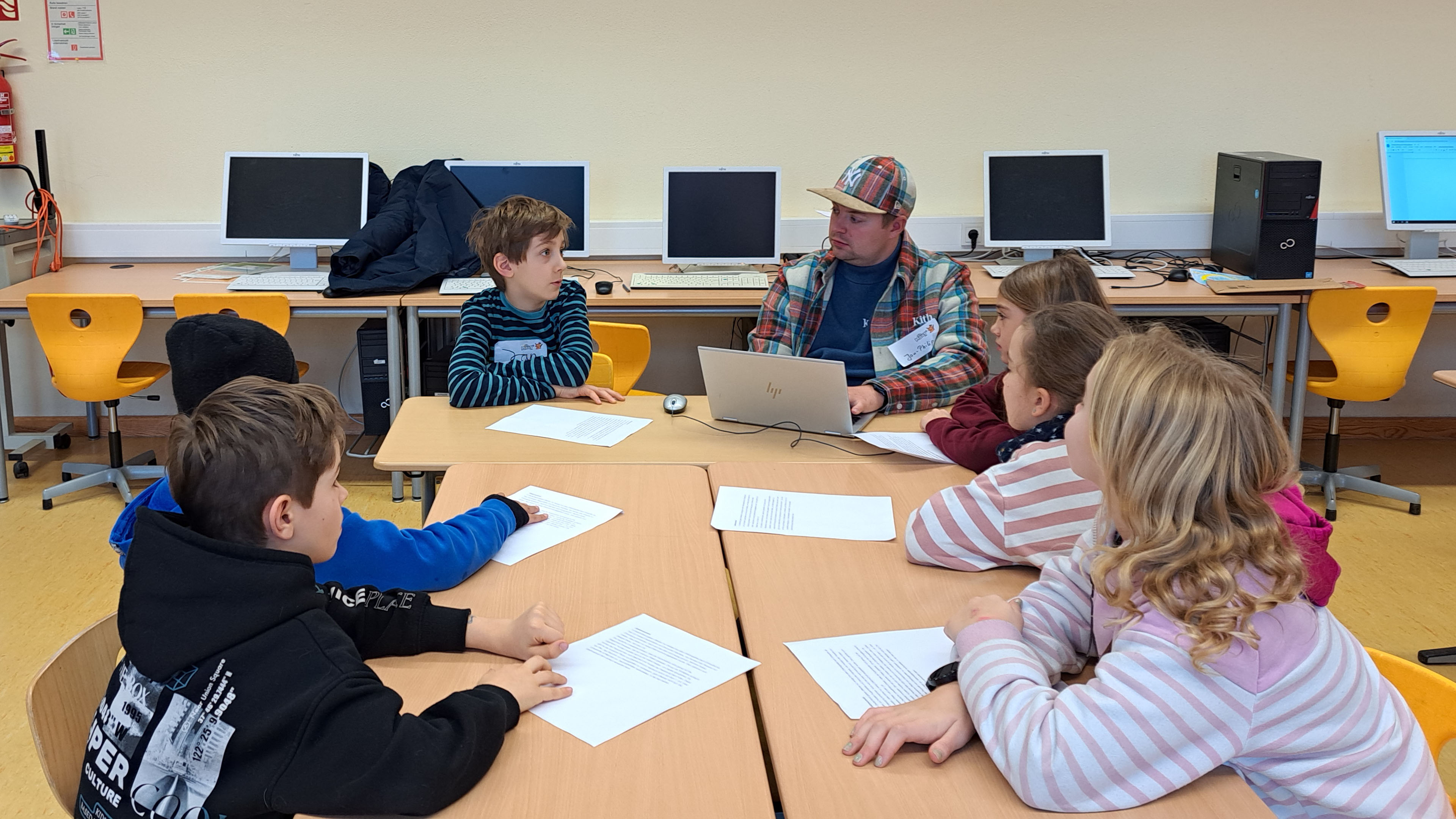 Kinder sitzen an einem Gruppentisch