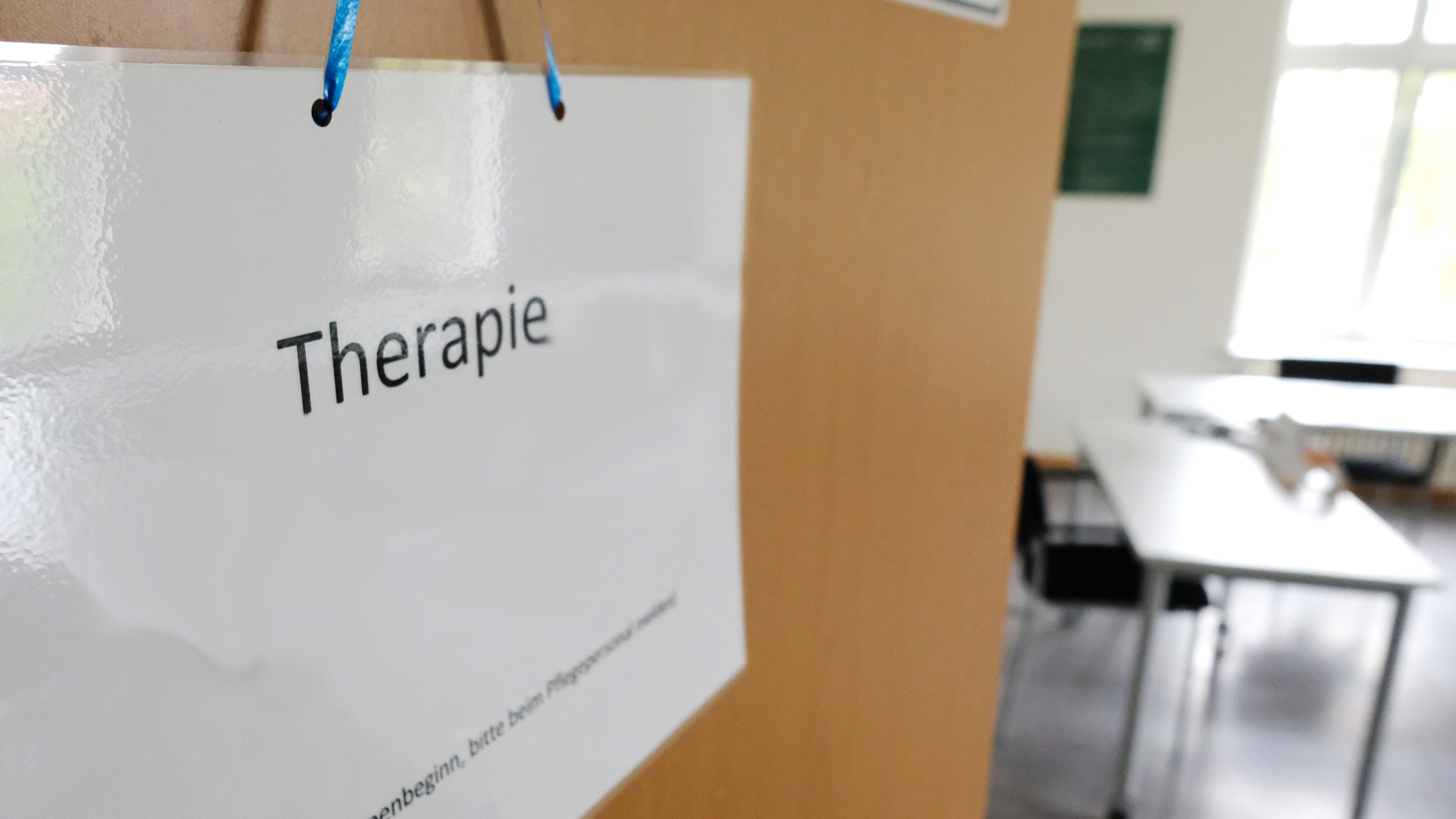 Schild mit der Aufschrift Therapie hängt an einer Tür