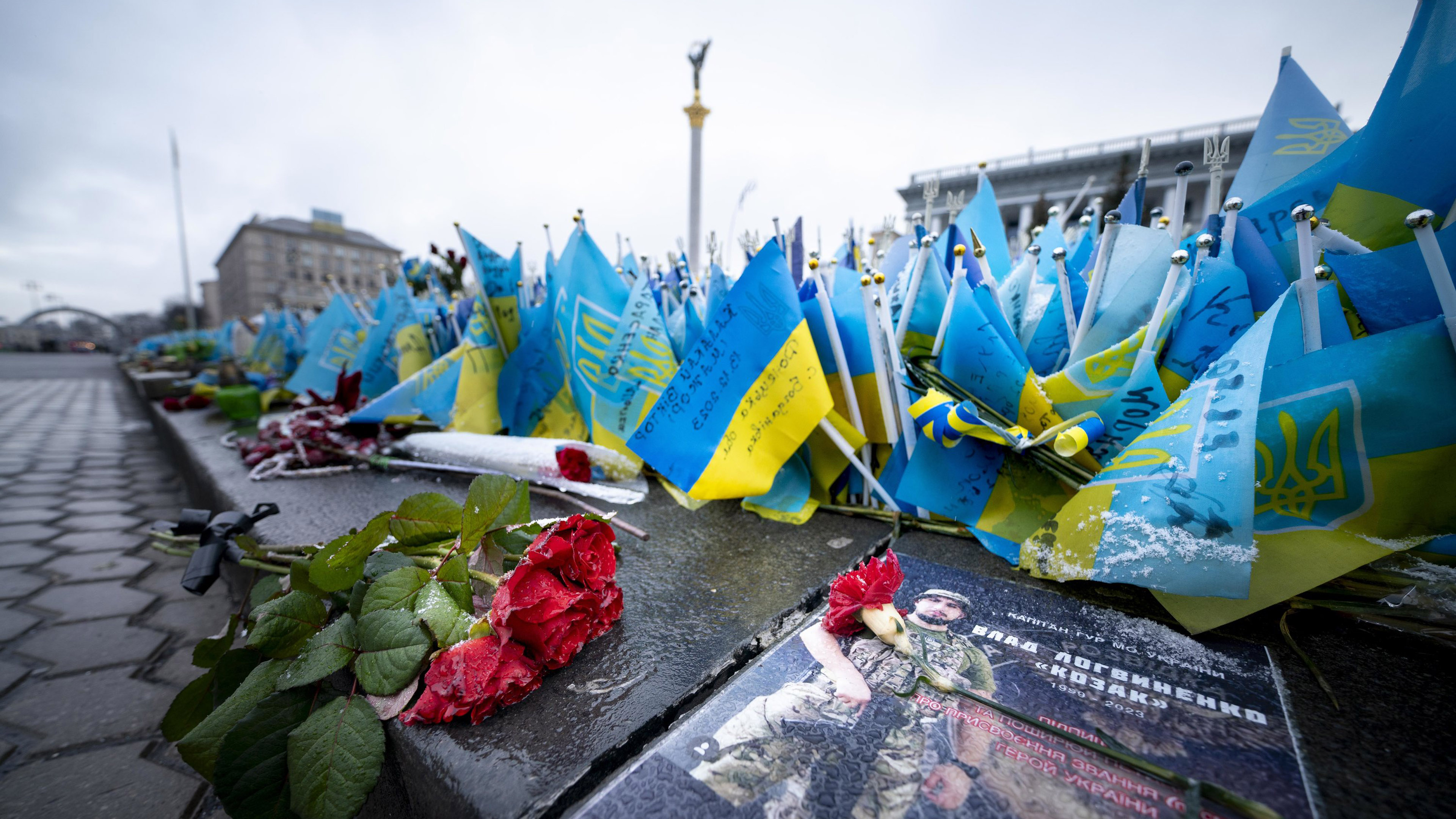Rosen und ukrainische Fahnen für Opfer der russischen Invasion in der Ukraine liegen auf dem Unabhängigkeitsplatz
