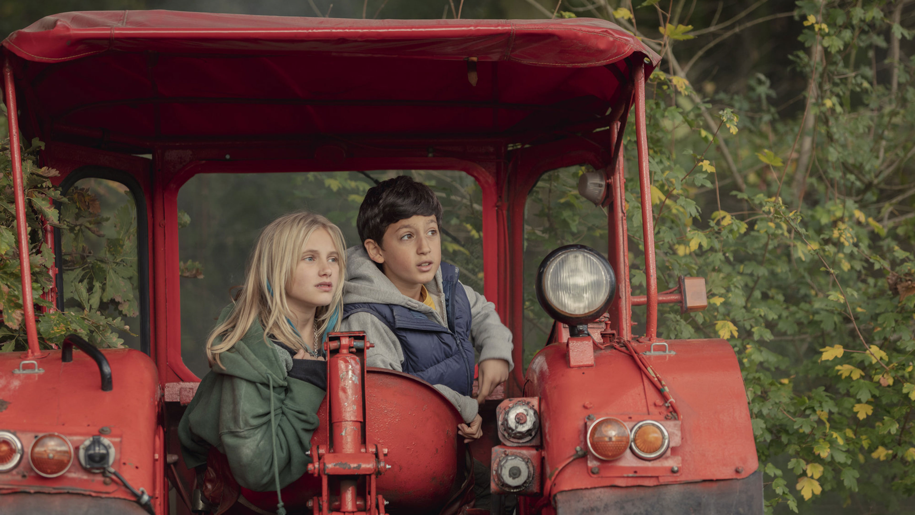 Zwei Kinder sitzen auf einem Traktor