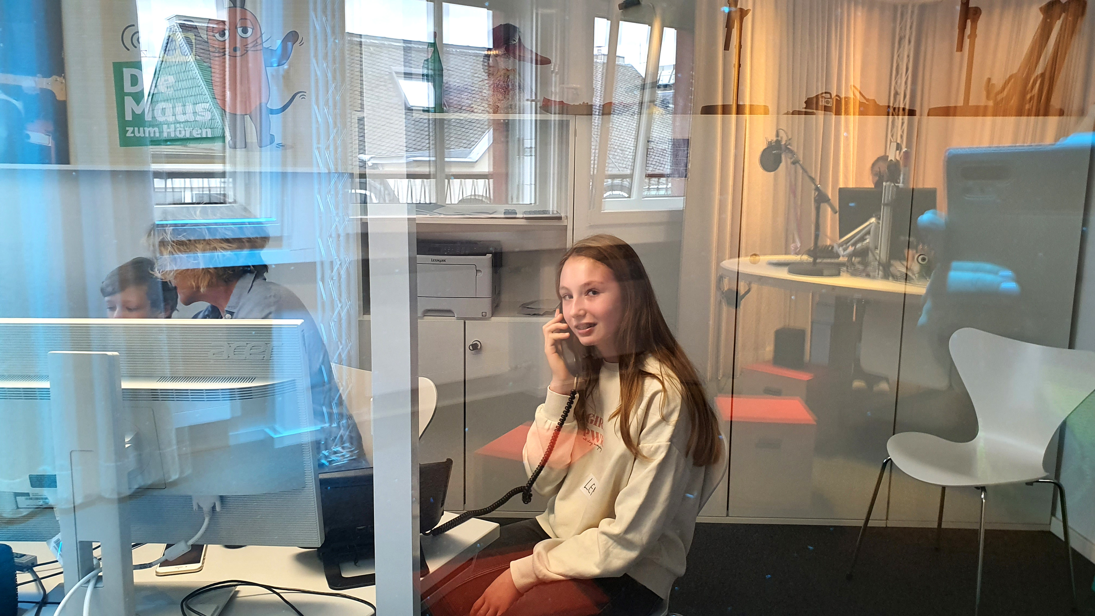 Mädchen telefoniert in der MausLive-Senderegie