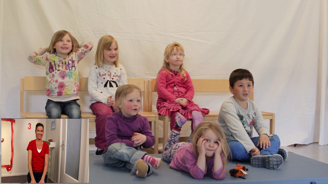 Sechs Kindergartenkinder auf Stühlen schauen in eine Richtung, lachen und rufen