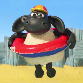 Kleines schwarzes Schaf Timmy in Schwimmreifen mit Badekappe