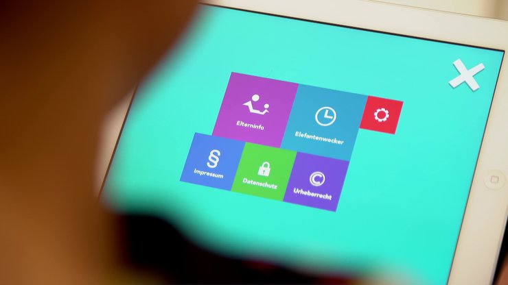 Person unscharf vor Tablet mit Elterninfos 