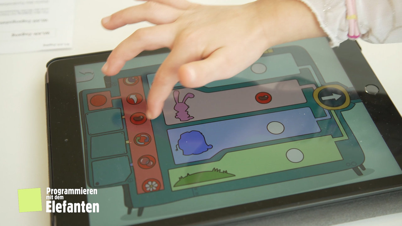 Kinderhand tippt auf Tablet und bedient die Elefanten App