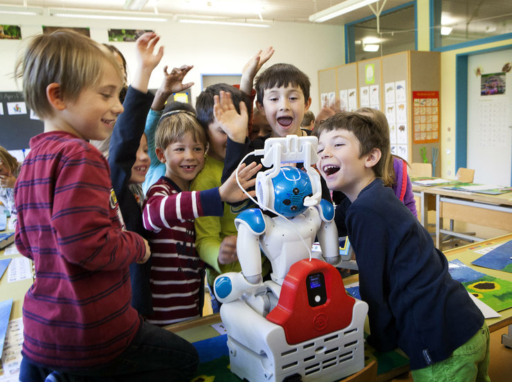 Kinder umringen einen kleinen Roboter