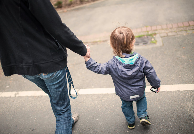 Ein Kind läuft an der Hand eines Erwachsenen
