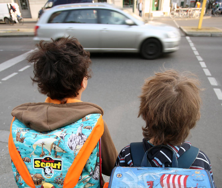 Zwei Jungen stehen an einem Straßenübergang