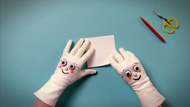 Zwei Hände mit Handschuhen falten weißes Papier