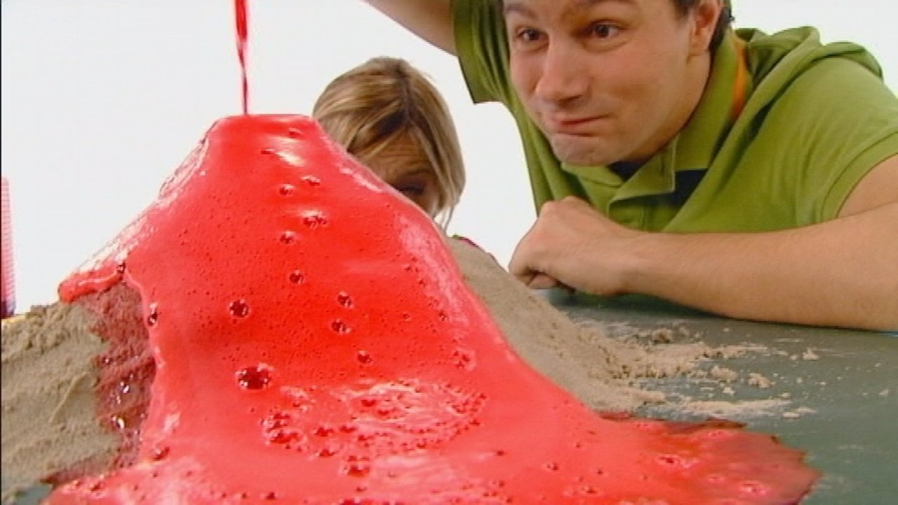 André kippt eine Flüssigkeit auf den Sandhügel, die rot schäumt