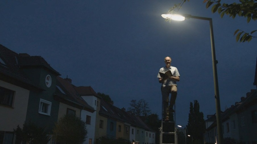 Vater liest unter Straßenlaterne