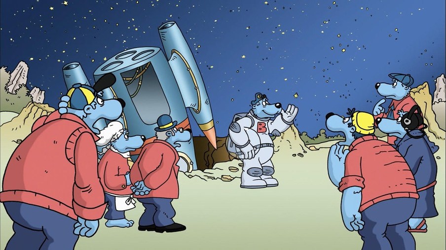 Käpt'n Blaubär steht im Kosmonautenanzug vor einem Raumschiff und wird von anderen Blaubären überrascht angeschaut