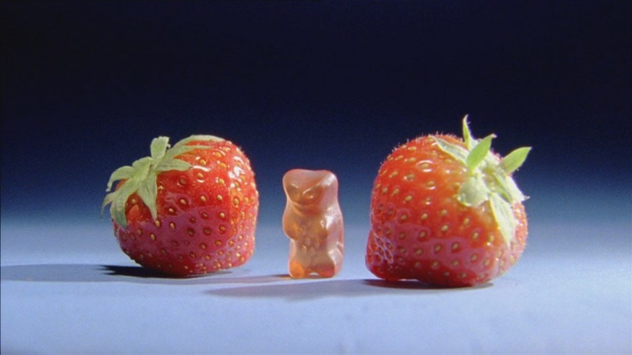Gummibärchen zwischen zwei Erdbeeren