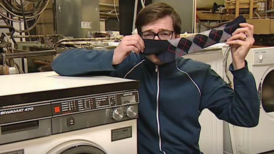 Ralph steht vor einer Waschmaschine und hält eine Socke