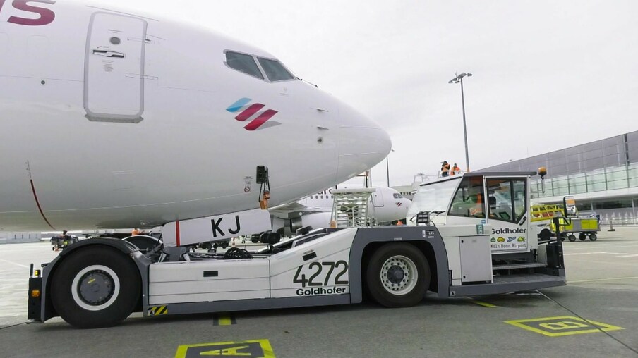 Ein Pushbacker auf einem Rollfeld, das ein Flugzeug schiebt