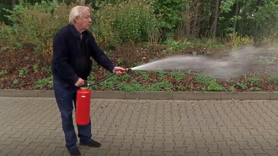 Armin benutzt einen Feuerlöscher.