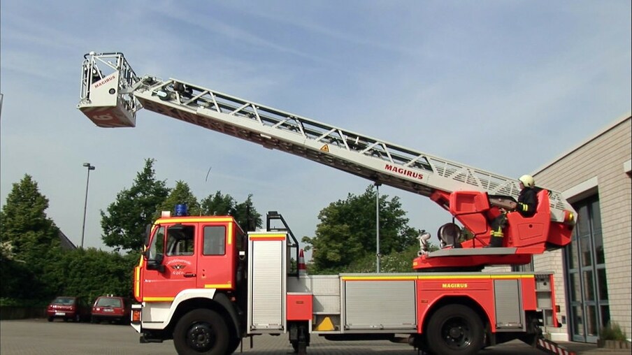 Feuerwehrwagen mit Leiter und einem Feuerwehrmann